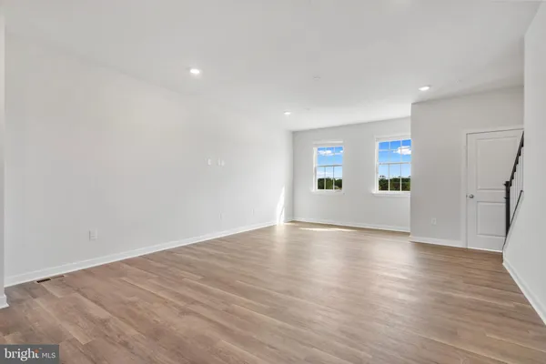 a view of a big room with wooden floor and windows