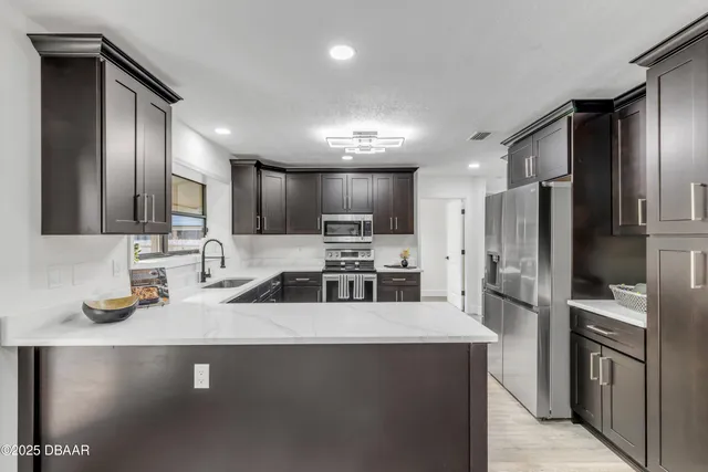 a kitchen with stainless steel appliances a refrigerator sink stove microwave and cabinets