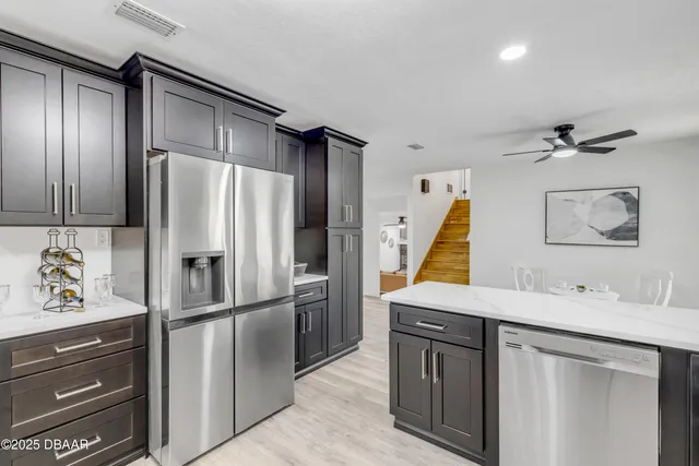 a living room with white cabinets and wooden floor
