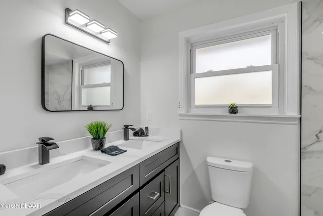 a bathroom with a toilet a sink and a window