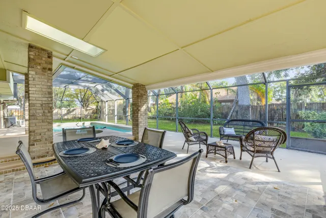 a patio with table and chairs and potted plants