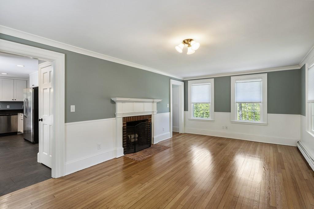 16 Bashaw Road Sutton, MA 01590 - Photo 9 of 37 an empty room with wooden floor a fireplace and windows