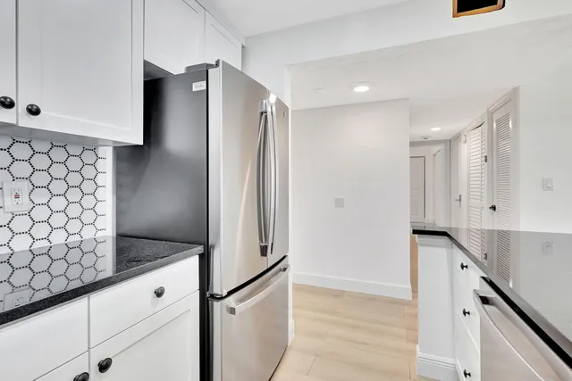 a kitchen with stainless steel appliances granite countertop a refrigerator and a sink