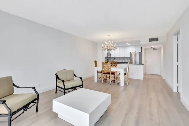 a living room with furniture and a dining table with kitchen view