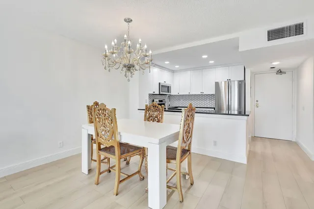 a view of a dining room with furniture and chandelier