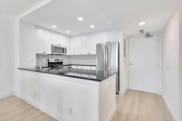 a kitchen with stainless steel appliances a refrigerator sink and microwave