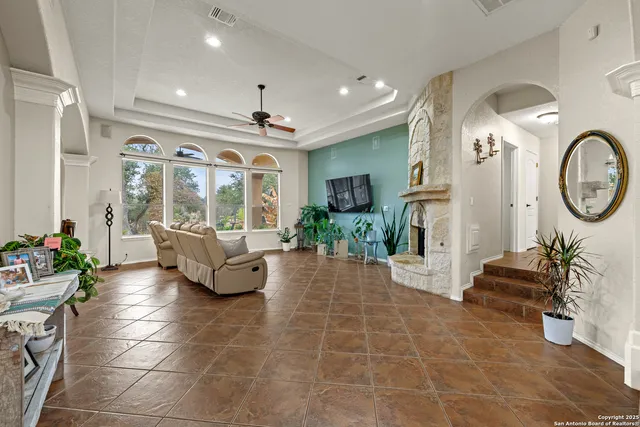 a living room with furniture a large window and a chandelier