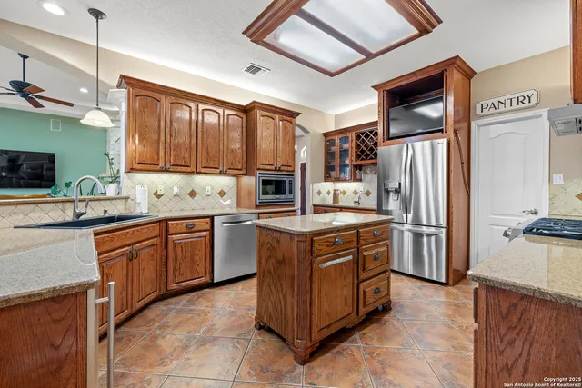 a kitchen with stainless steel appliances granite countertop a refrigerator stove and sink