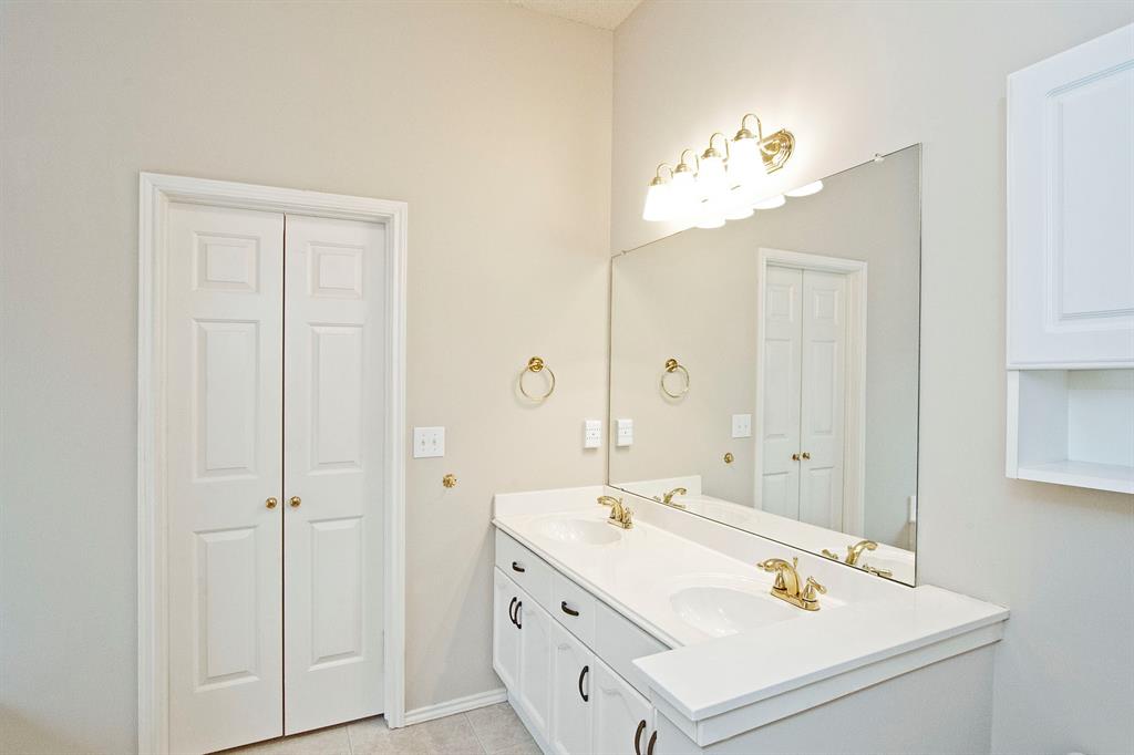 7757 Lancelot Road Frisco, TX 75035 - Photo 21 of 27 Bathroom with double vanity, baseboards, and a sink