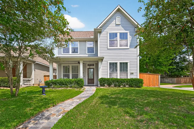 a front view of a house with a yard and green space