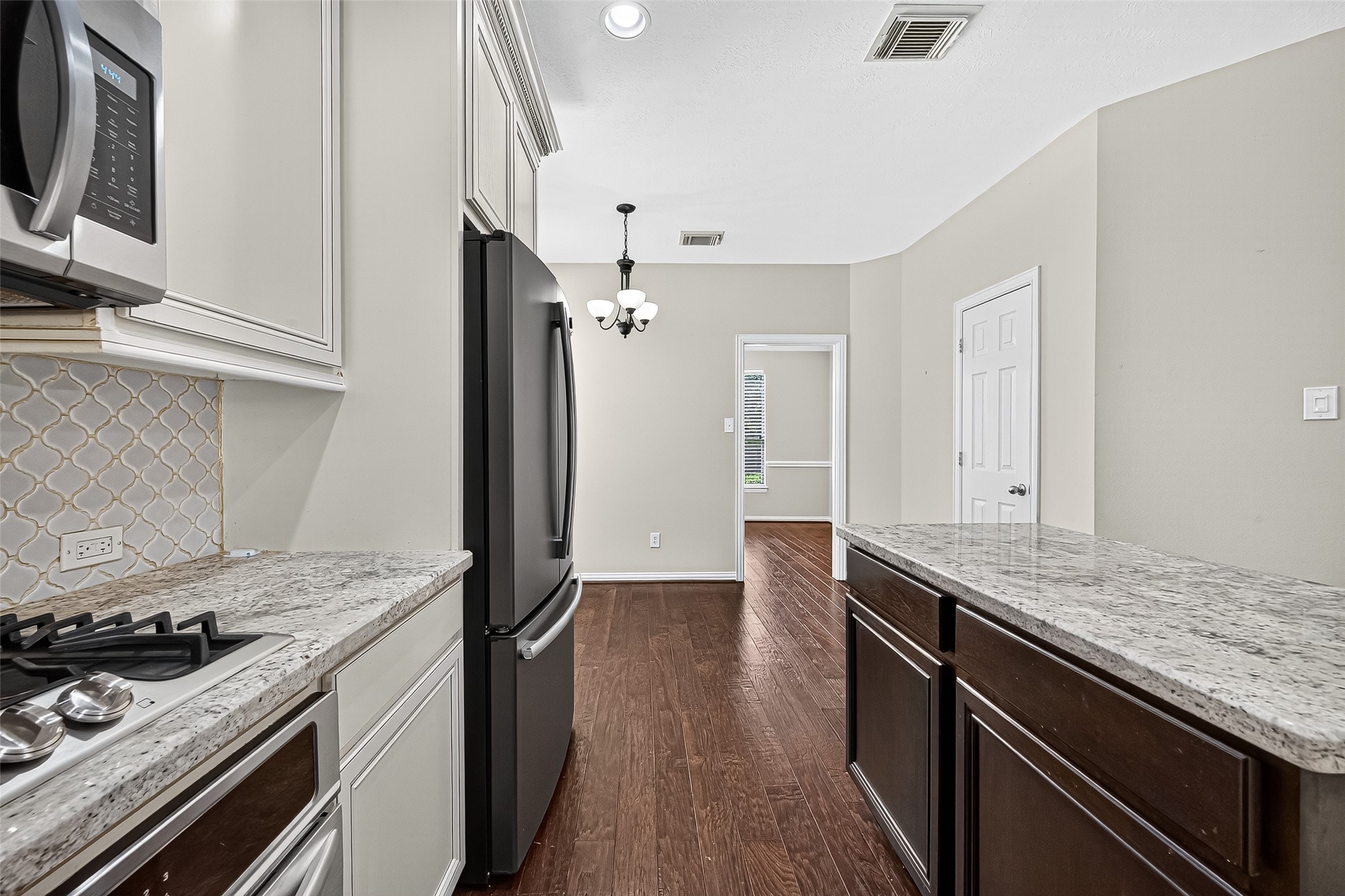 30 Whetstone Ridge Way The Woodlands, TX 77382 - Photo 20 of 39 a kitchen with granite countertop a stove and a wooden floors