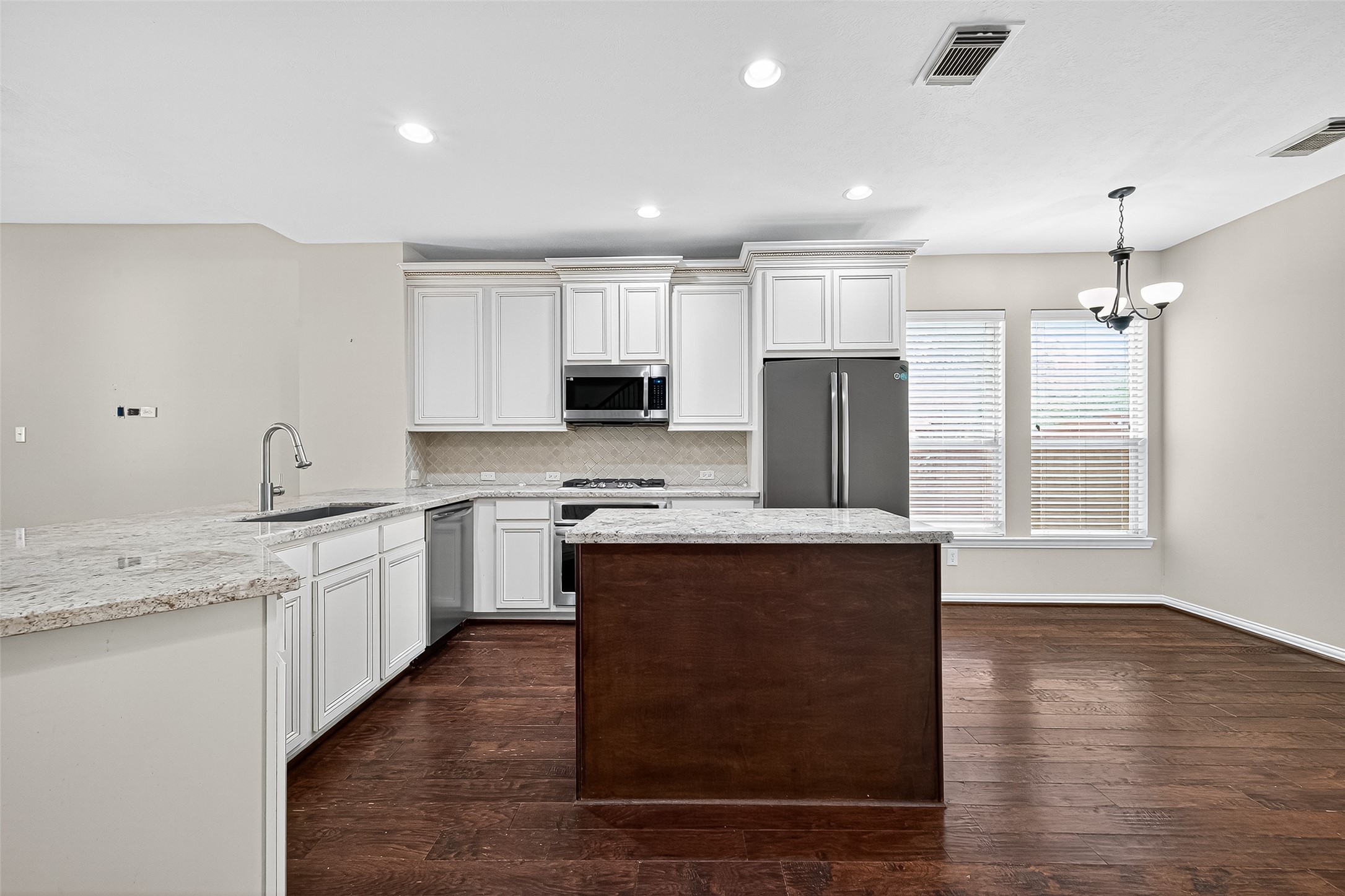 30 Whetstone Ridge Way The Woodlands, TX 77382 - Photo 21 of 39 a kitchen with stainless steel appliances granite countertop a stove a sink dishwasher a refrigerator and white cabinets with wooden floor