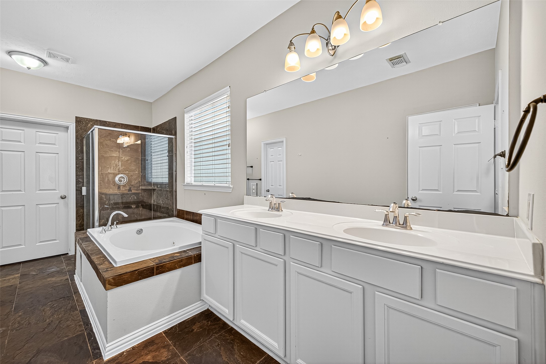 30 Whetstone Ridge Way The Woodlands, TX 77382 - Photo 25 of 39 a bathroom with a double vanity sink a mirror and a bathtub