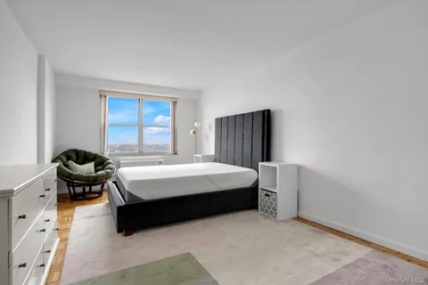 a bedroom with a bed chair and window