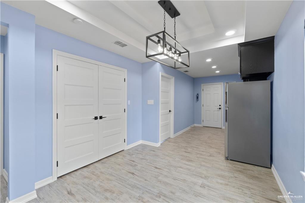 2118 Earth Lane Mission, TX 78573 - Photo 19 of 26 a view of a hallway with wooden floor and a chandelier