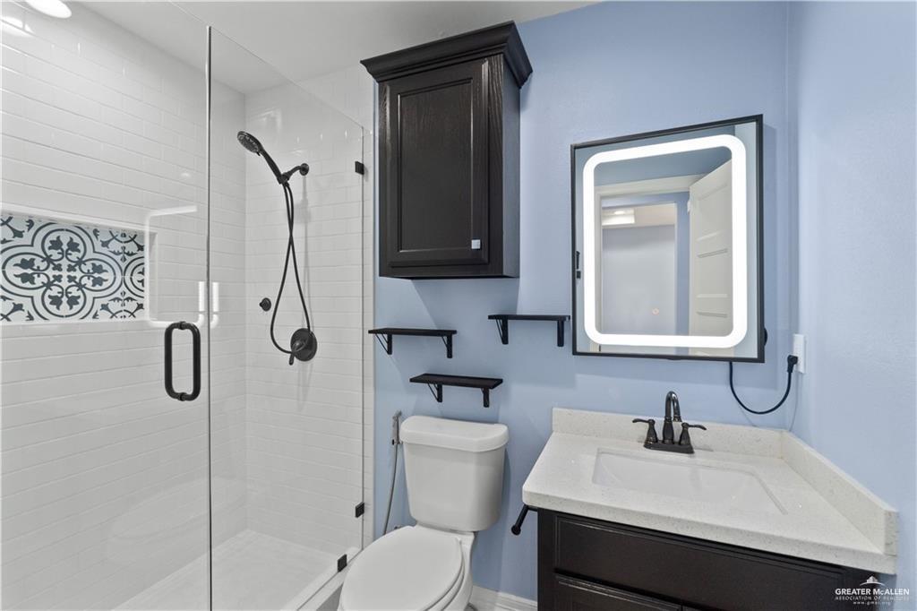 2118 Earth Lane Mission, TX 78573 - Photo 22 of 26 a bathroom with a sink a toilet and shower