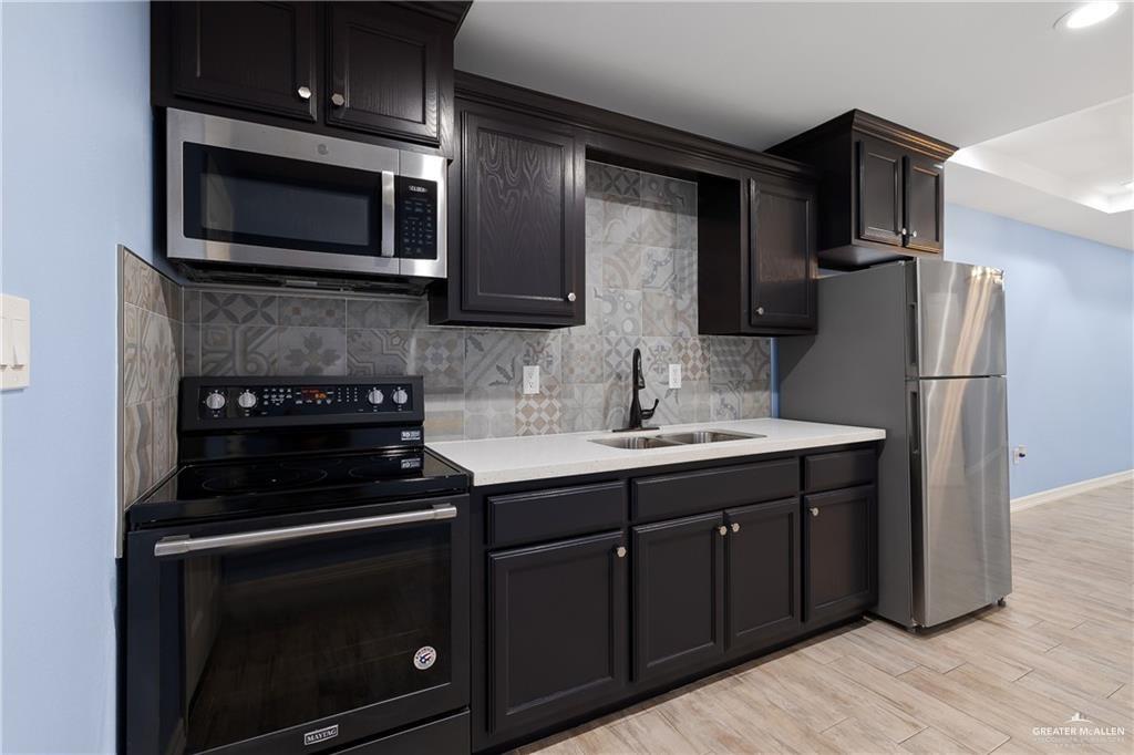 2118 Earth Lane Mission, TX 78573 - Photo 4 of 26 a kitchen with a sink stove and microwave