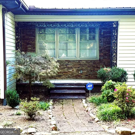 a front view of a house with a garden