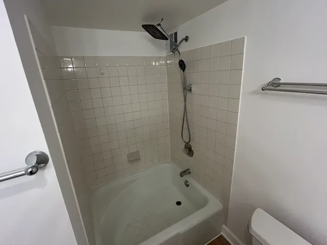 an empty room with wooden floor and a ceiling fan