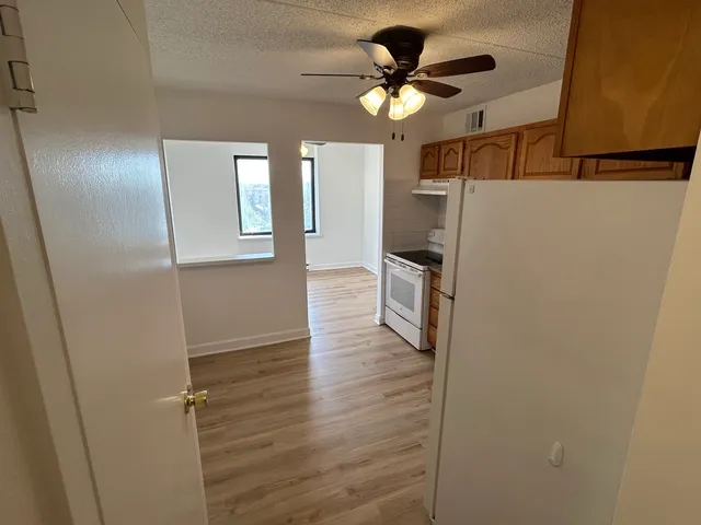 a kitchen with a refrigerator a stove top oven a sink and cabinets