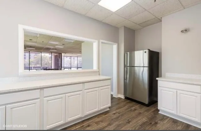 a room with lots of furniture a large window and a table