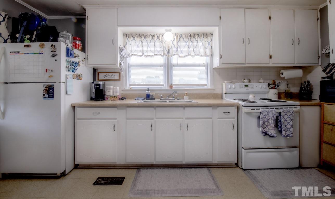 3795 Seven Paths Road Louisburg, NC 27549 - Photo 7 of 21 a kitchen with a sink a refrigerator and window