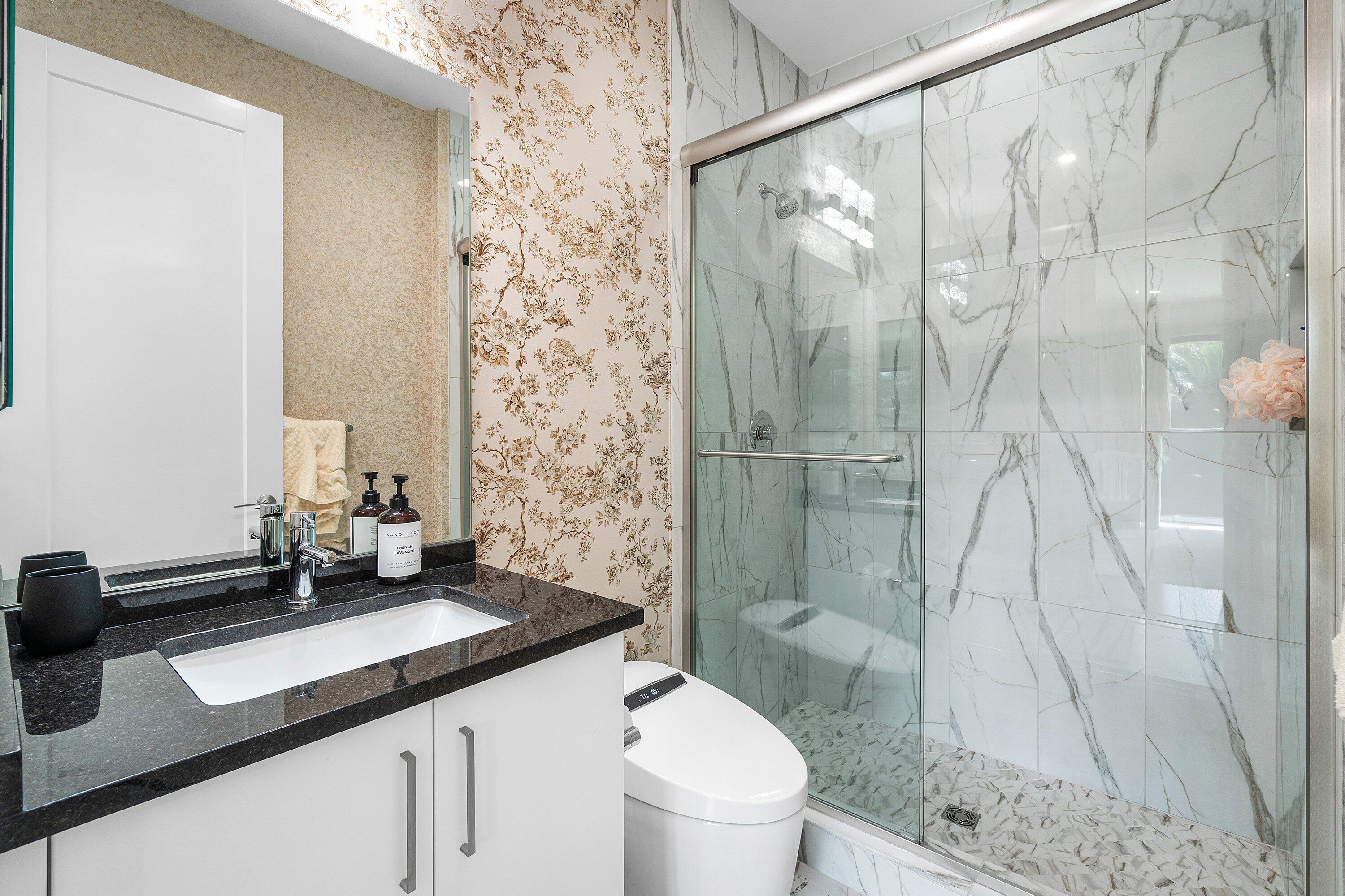 8233 Crystal Downs Avenue Boca Raton, FL 33434 - Photo 43 of 58 a bathroom with a granite countertop sink a toilet and shower