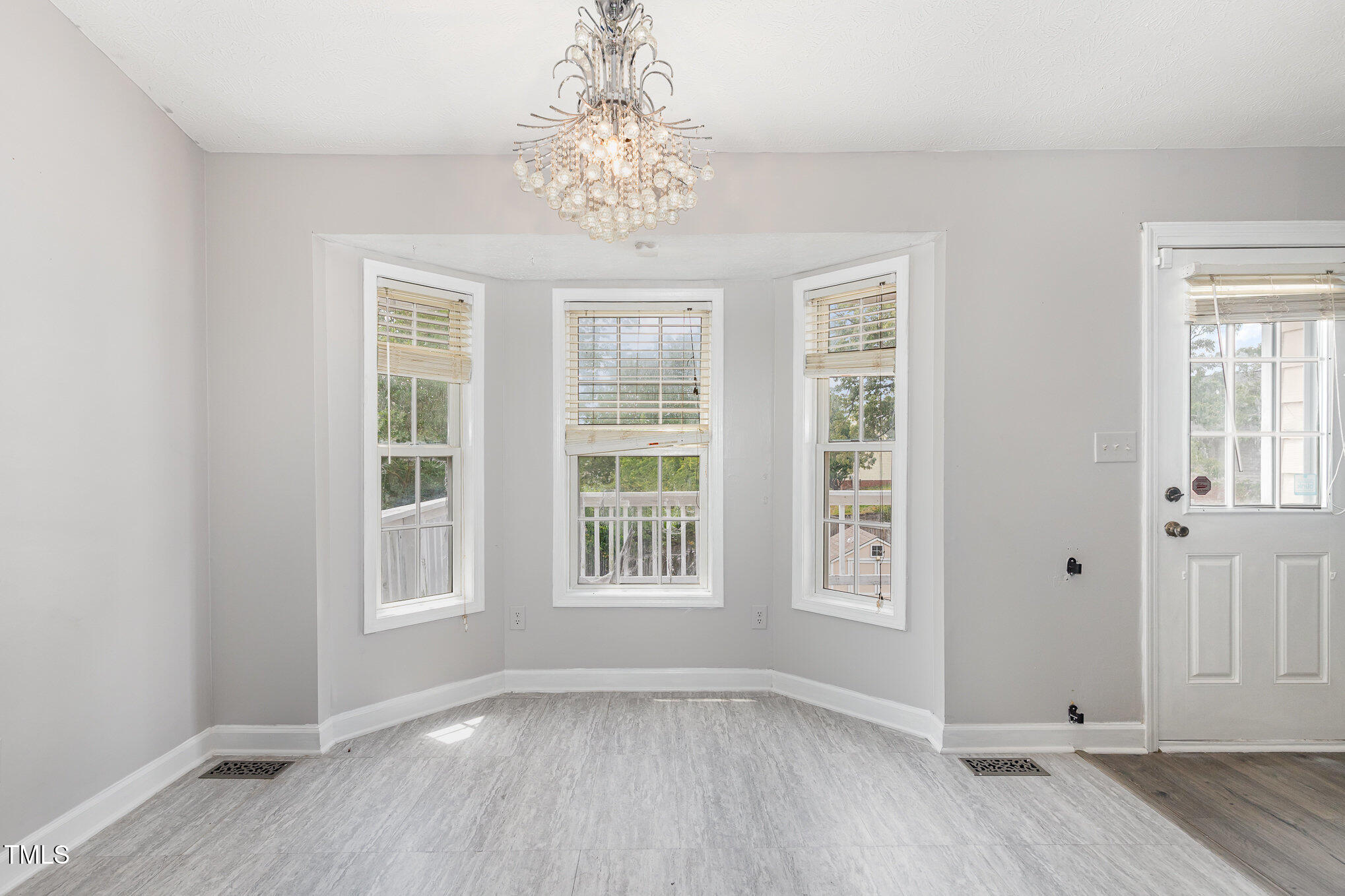 3485 Green Valley Road Fayetteville, NC 28311 - Photo 12 of 28 an empty room with wooden floor chandelier and windows