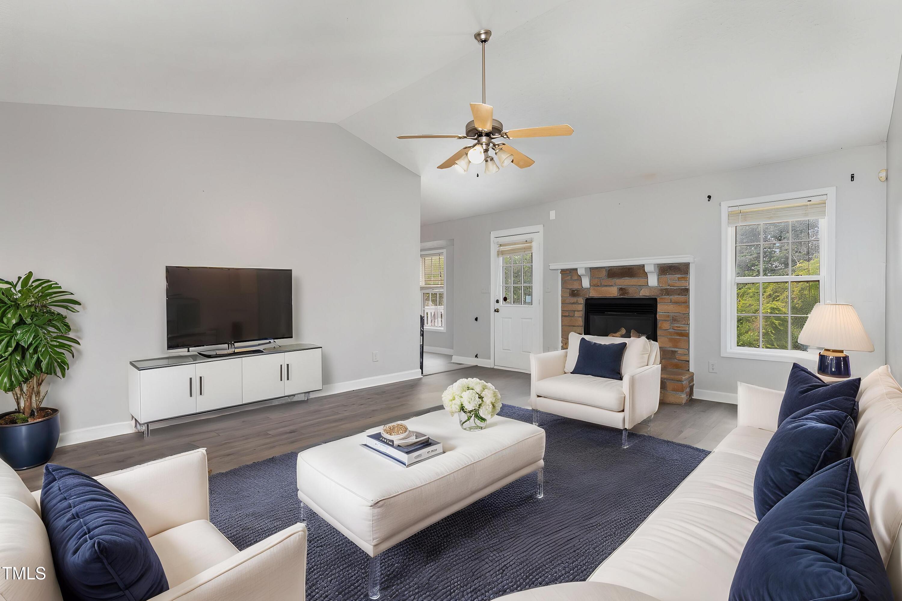3485 Green Valley Road Fayetteville, NC 28311 - Photo 5 of 28 a living room with furniture a flat screen tv and a fireplace