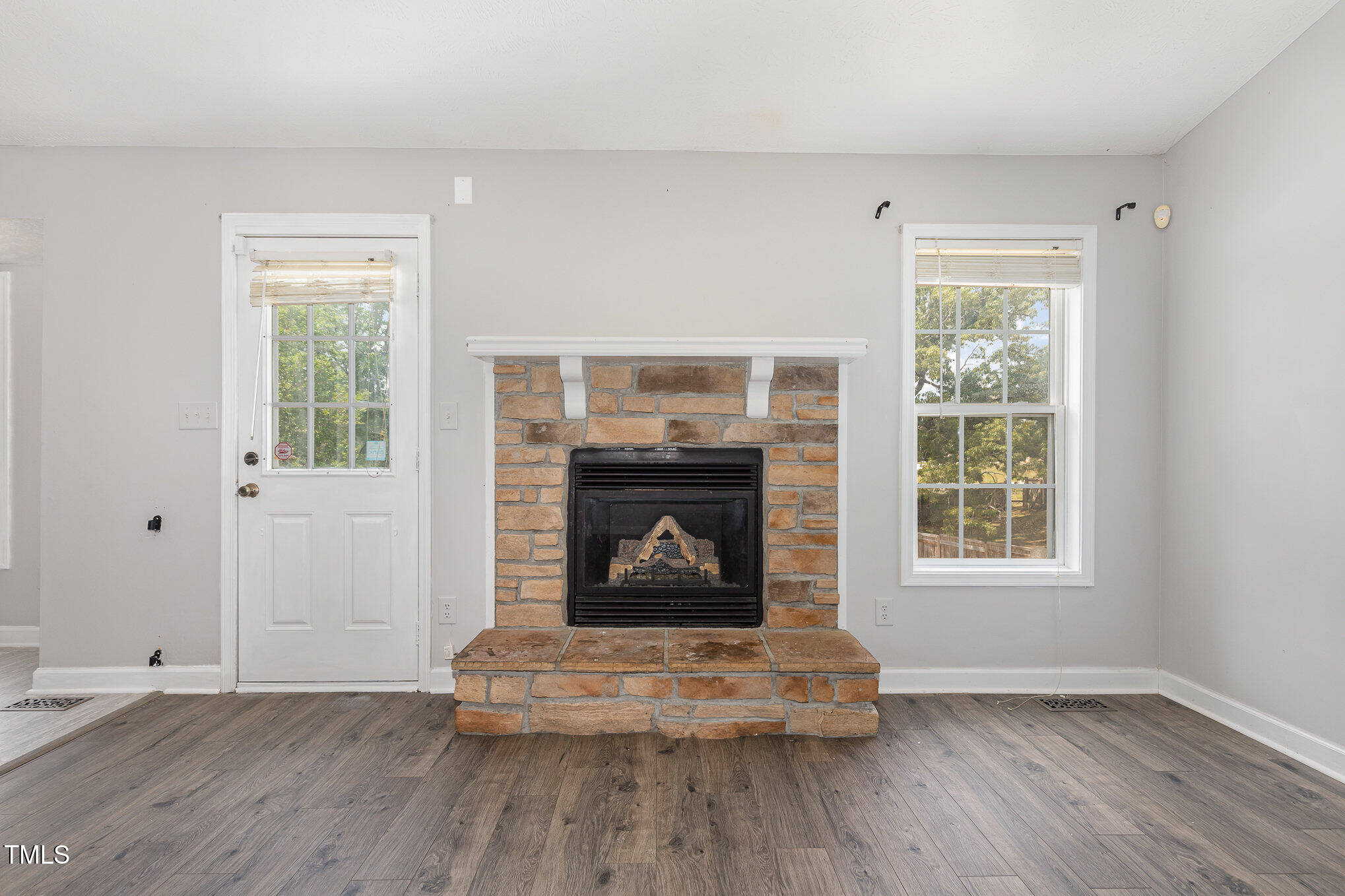 3485 Green Valley Road Fayetteville, NC 28311 - Photo 6 of 28 an empty room with wooden floor fireplace and windows