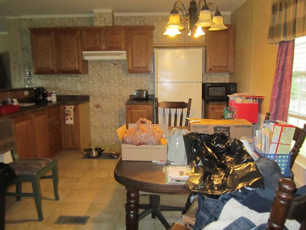 148 5th Road, Unit 20 Haddock, GA 31033 - Photo 3 of 12 a kitchen with stainless steel appliances a stove a sink a microwave a dining table and chairs