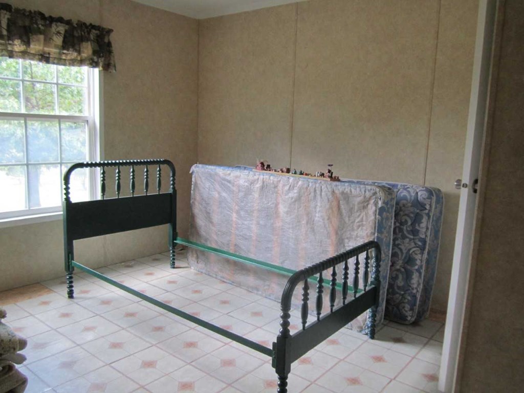 148 5th Road, Unit 20 Haddock, GA 31033 - Photo 7 of 12 a bed sitting in a bedroom next to a window