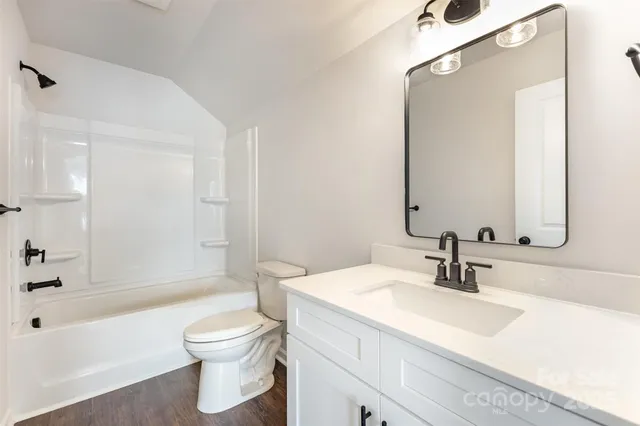 a bathroom with a sink a toilet and a large mirror