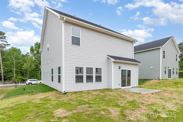 a view of a house with backyard and a tree