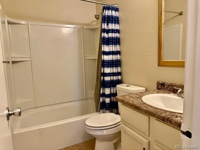 a bathroom with a granite countertop toilet sink and shower
