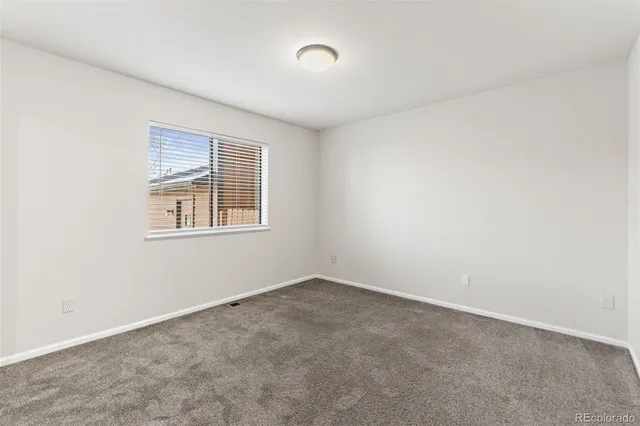 an empty room with closet and a window