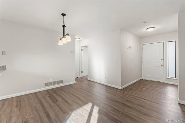 a view of kitchen with refrigerator wooden floor and window