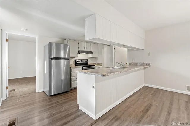 a kitchen with granite countertop a sink and refrigerator