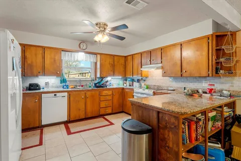 a kitchen with stainless steel appliances granite countertop a sink window and cabinets