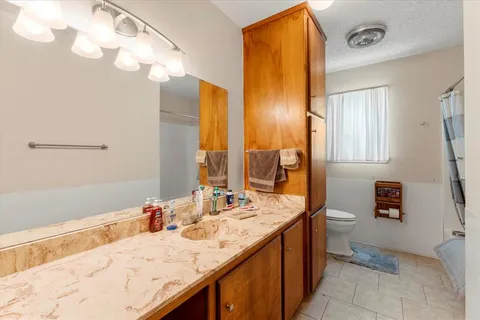 a bathroom with a granite countertop sink and a mirror