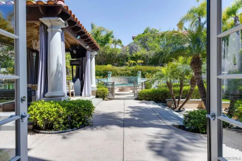 a view of a house with a yard and potted plants