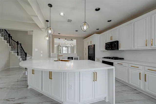 a kitchen with stainless steel appliances kitchen island hardwood floor and a sink