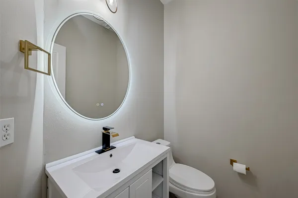 a bathroom with a sink mirror and toilet