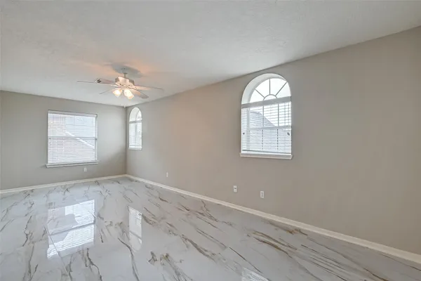 an empty room with windows and fan