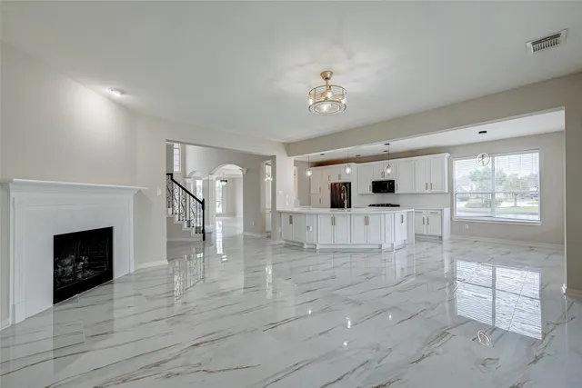 an empty room with wooden floor and fireplace