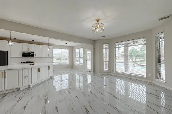 a large white kitchen with wooden floors and white cabinets