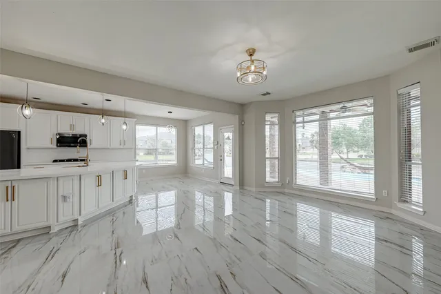 a large white kitchen with wooden floors and white cabinets