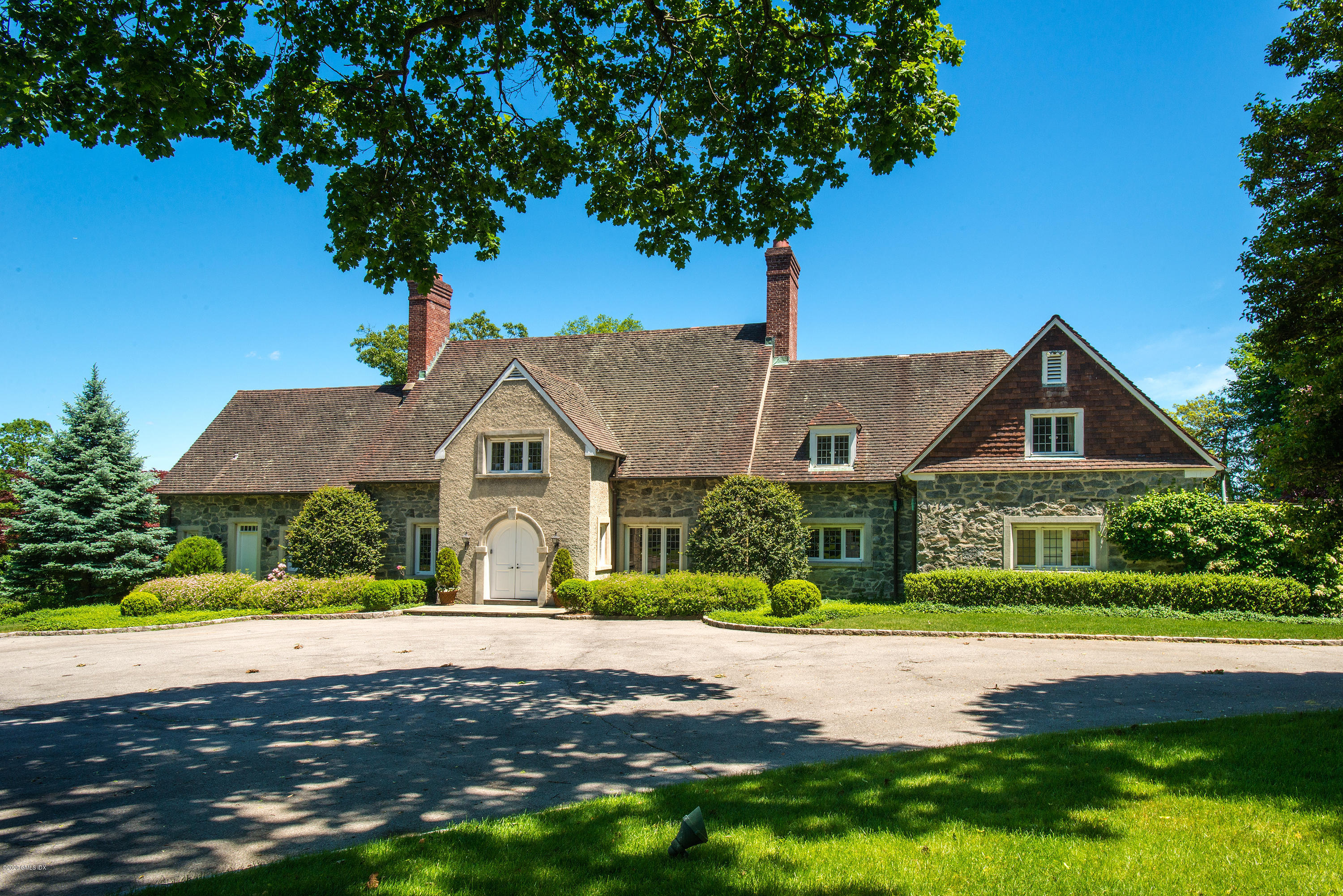 140 Field Point Circle Greenwich, CT 06830 - Photo 2 of 19 a front view of a house with a garden