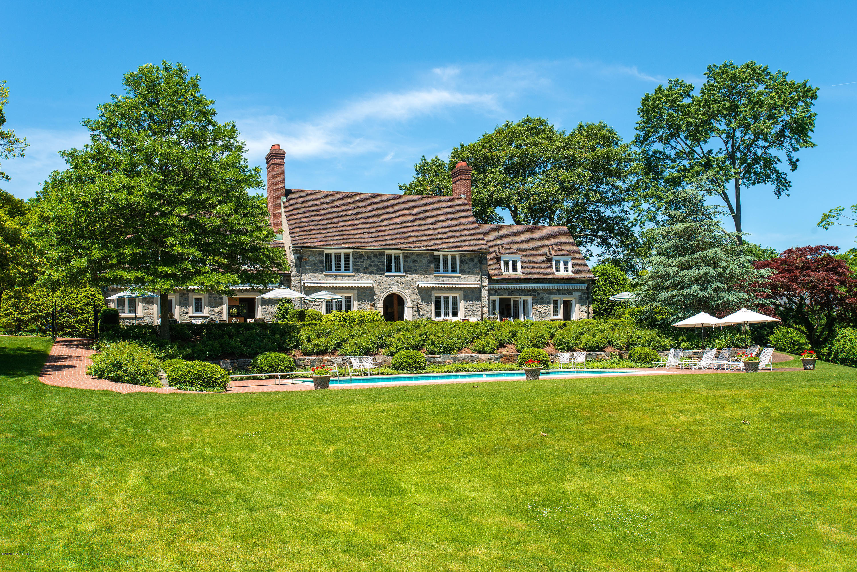140 Field Point Circle Greenwich, CT 06830 - Photo 5 of 19 a front view of a house with a yard table and chairs