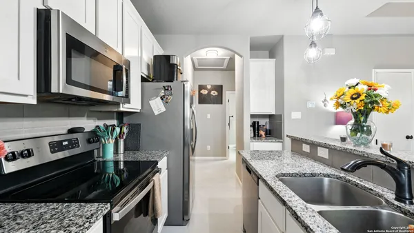 a kitchen with stainless steel appliances granite countertop a sink a stove and a refrigerator